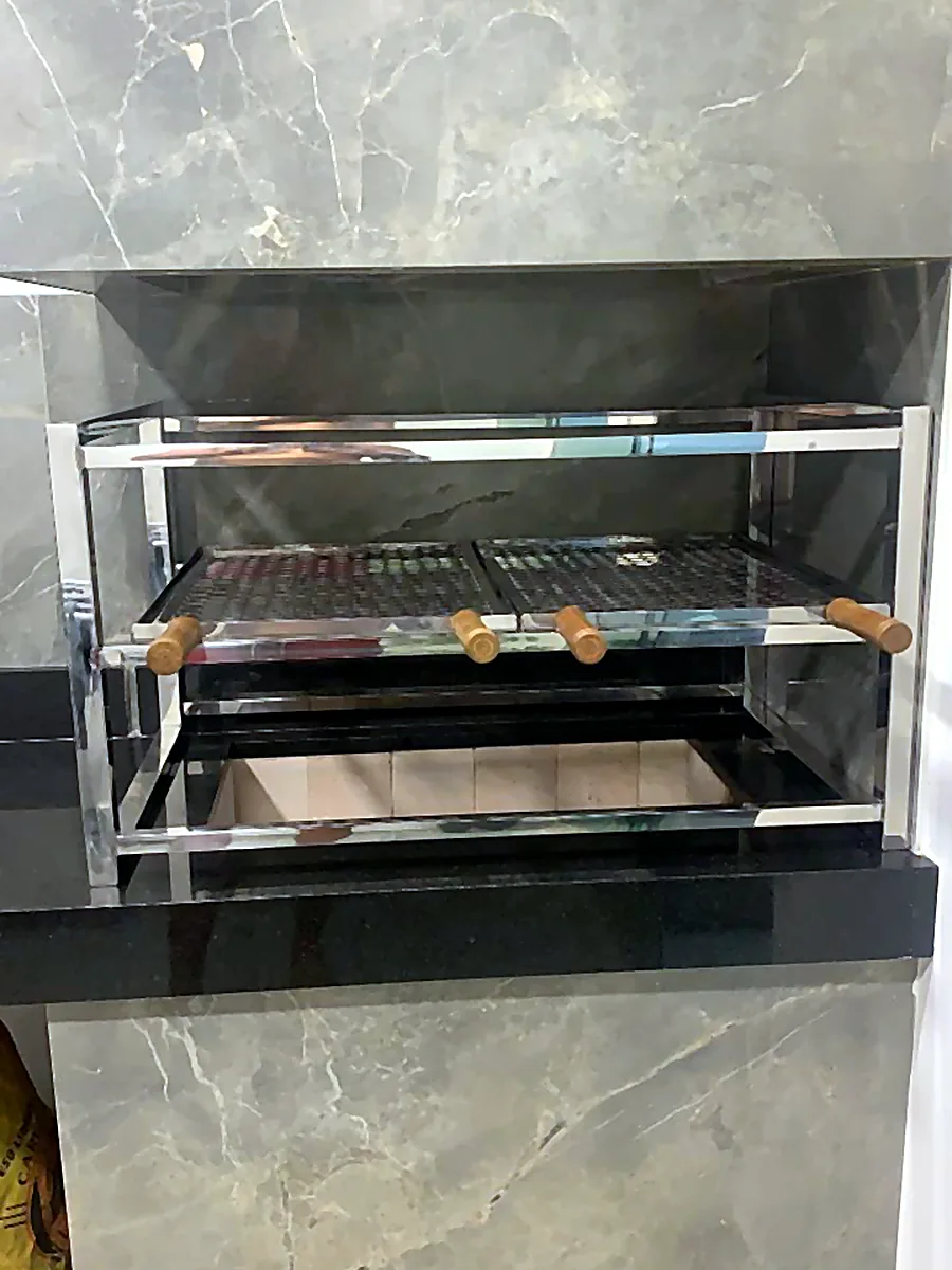 Churrasqueira de inox embutida em parede revestida de porcelanato