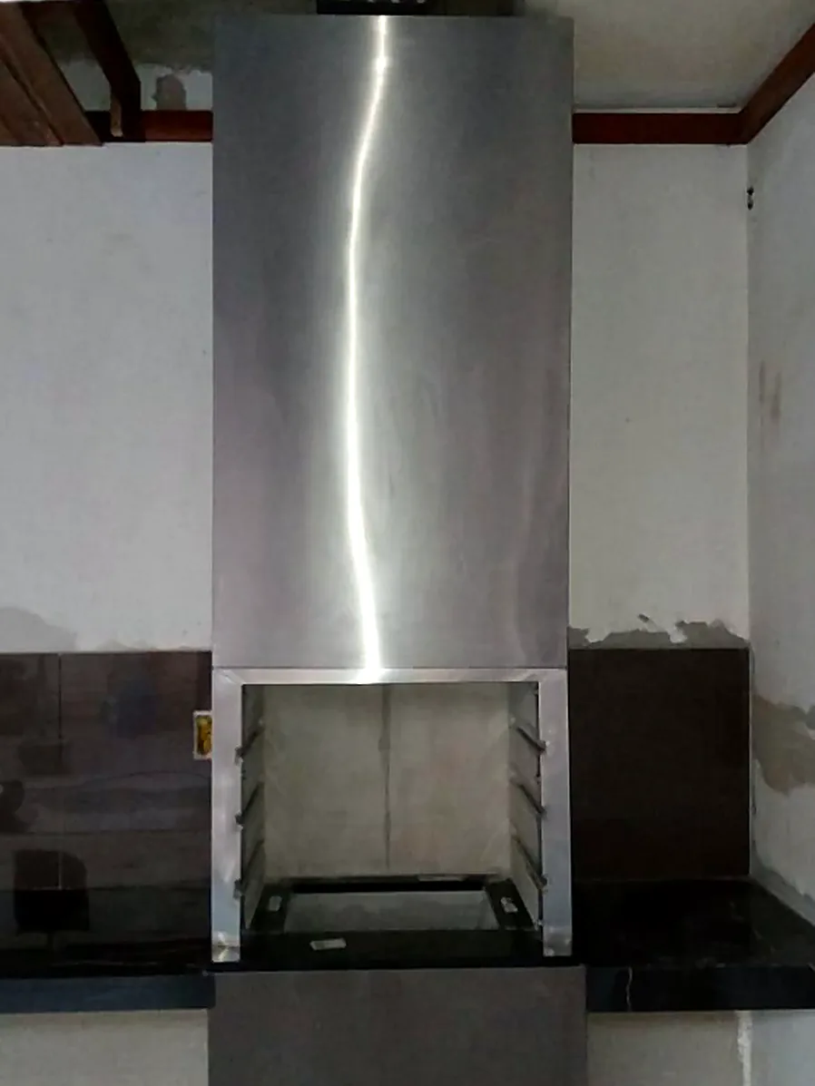 Coifa em inox com duto cilíndrico aparente em área gourmet