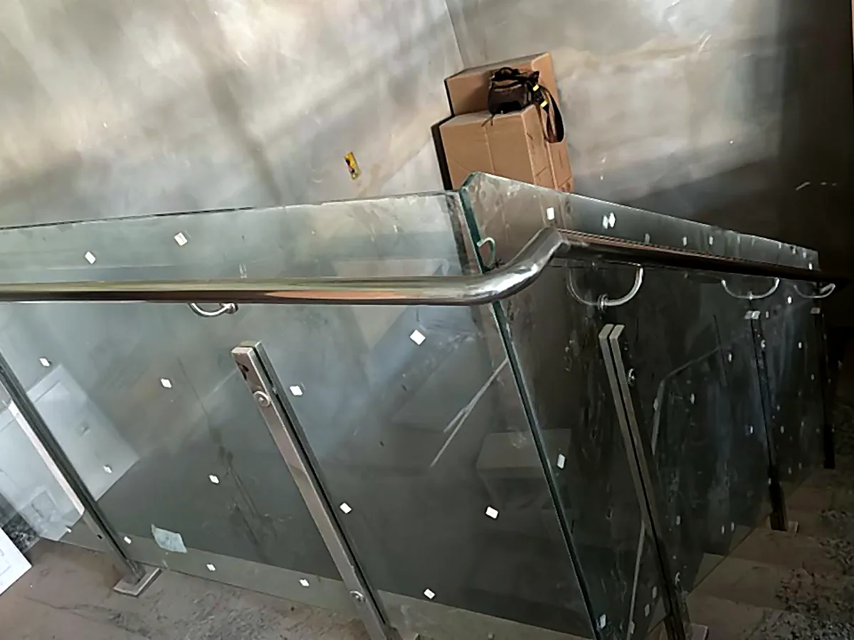 Detalhe da fixação de guarda-corpo de inox com painel de vidro